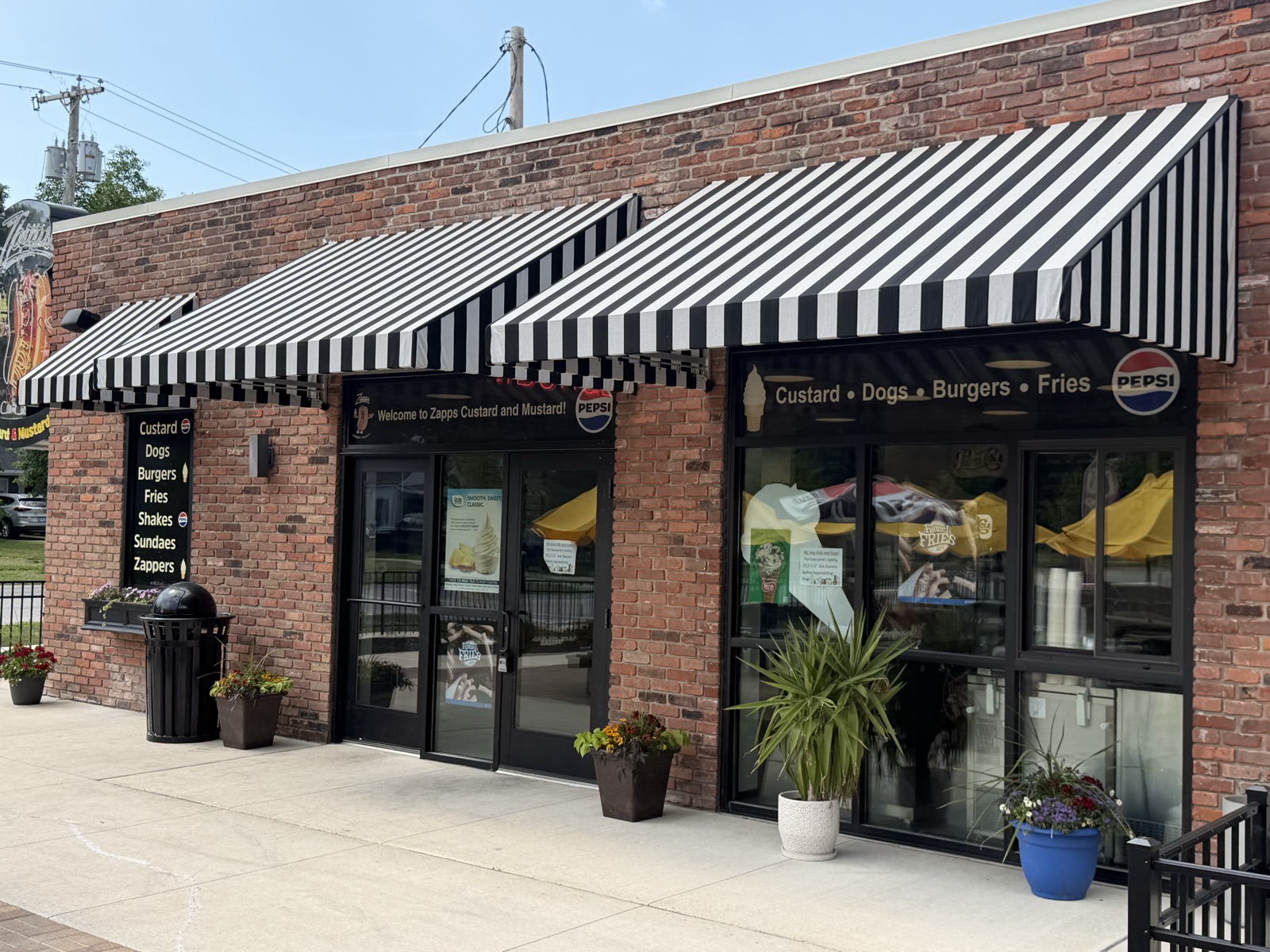 Zapps brick storefront with black and white striped awnings