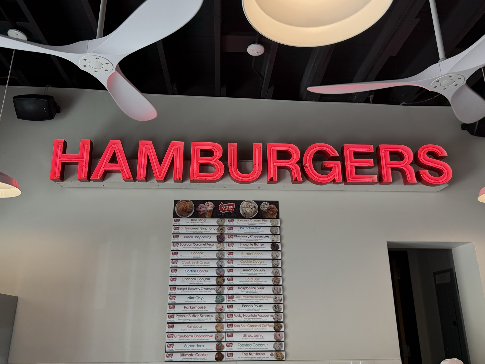 Neon hamburgers sign and Perry's flavor board inside Zapps